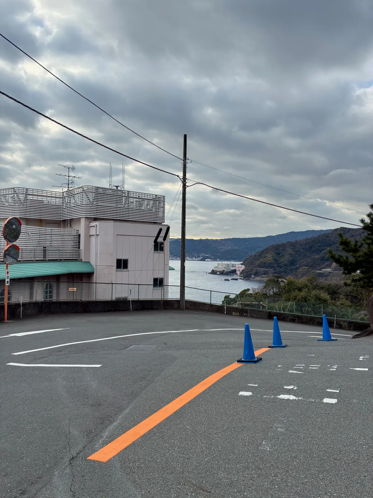 坂道のカーブと、その先に見える湾や周囲の建物